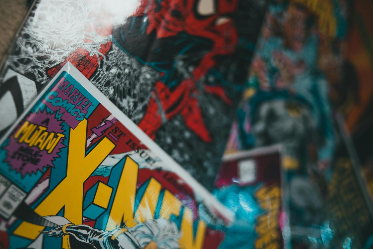 A close-up view of several colorful comic books, with a clear focus on an X-Men 